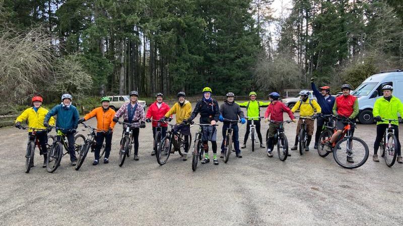 An image of a group of gasping geezer mountain bikers with their bikes